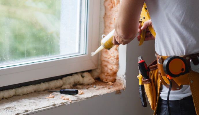 Person repairing leaky window with equipment